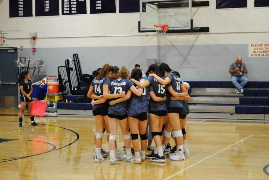 The girls volleyball team huddles during the match.