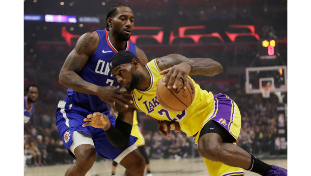 Los Angeles Lakers LeBron James, right, is defended by Los Angeles Clippers Kawhi Leonard during the first half of an NBA basketball game Tuesday, Oct. 22, 2019, in Los Angeles. (AP Photo/Marcio Jose Sanchez)