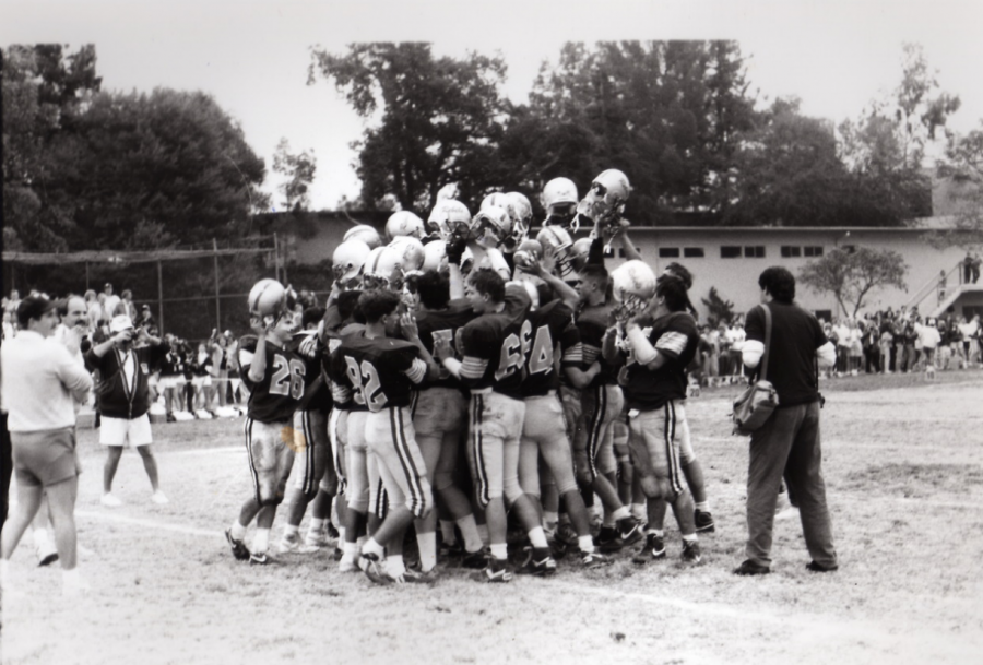 Rebel football players meet in a huddle in this archival photo from the 1980s.